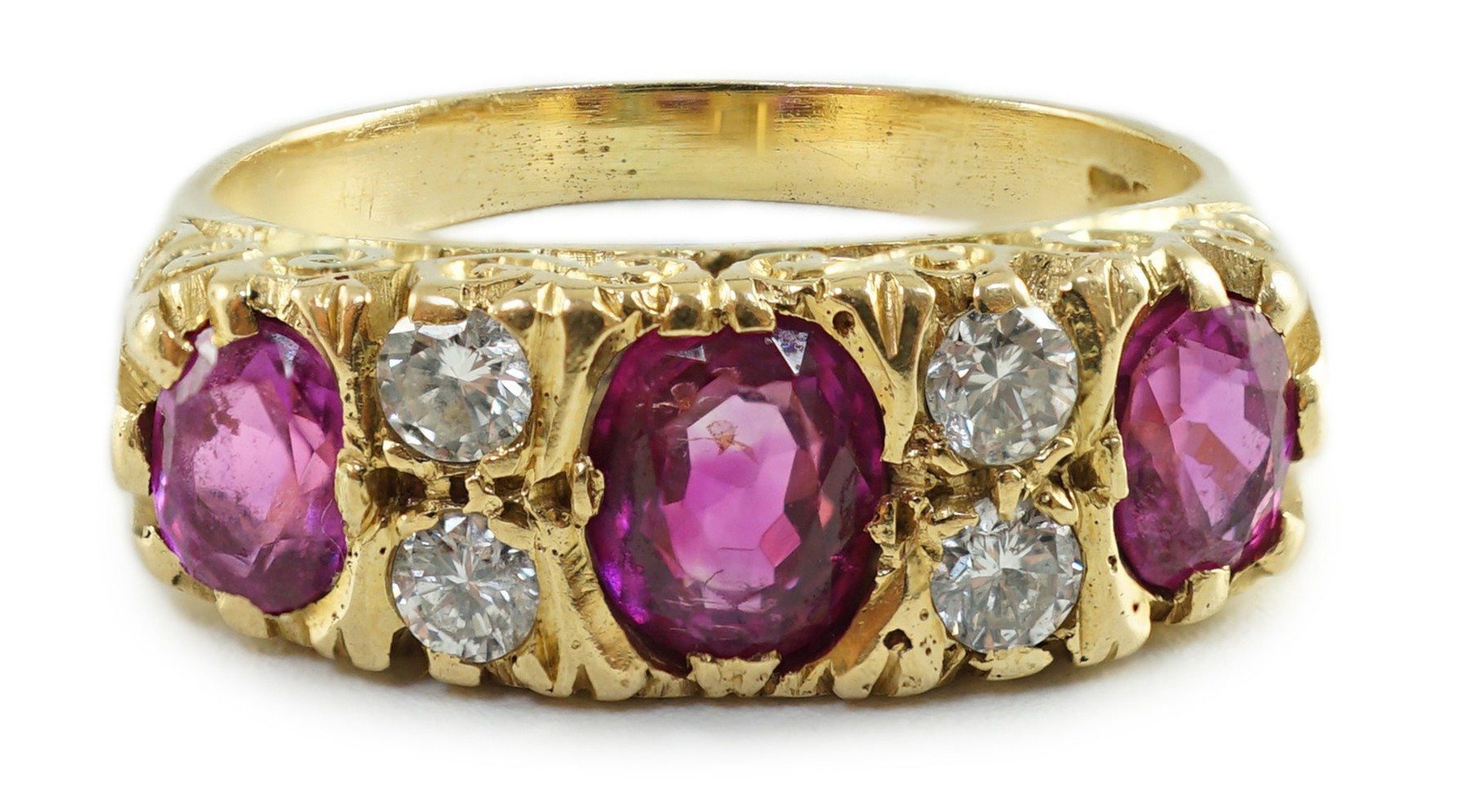 An early to mid 20th century 18ct gold, single stone oval cut ruby, two stone pink sapphire and four stone round cut diamond set half hoop ring